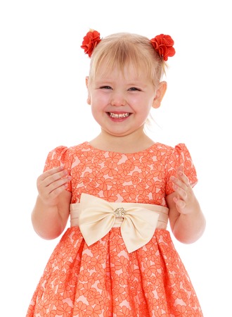 Closeup of a smiling little girl in a lush orange dress-Isolated on white backgroundの写真素材