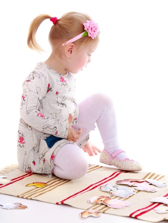 Little girl in a Montessori kindergarten playing sitting on the Mat-Isolated on white backgroundの写真素材