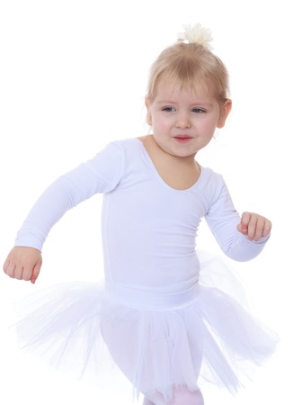 The little blonde girl in a white sports dress up-isolated on white backgroundの写真素材