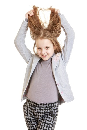 A teenage girl develops hands her hair-Isolated on white backgroundの写真素材