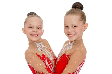 Two sisters funny gymnasts hugging each other, close-up-Isolated on white backgroundの写真素材