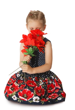 Pretty little girl in a long silk dress smelling a bouquet of red flowers . The girl's face is almost completely closed by the bouquet-Isolated on white backgroundの写真素材