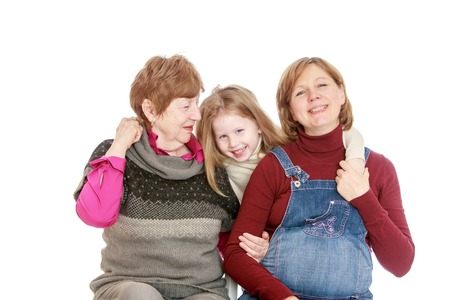 Happy grandmother and a young pregnant mom in the arms of his beloved daughter and granddaughter. Closeup - Isolated on white background.The concept of the celebration and the value of family relationships.の写真素材