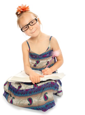 Girl makes pencil marks in the book - Isolated on white backgroundの写真素材