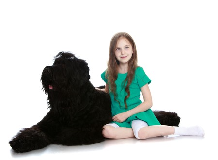 Cute little girl hugging a big black dog-Isolated on white backgroundの写真素材