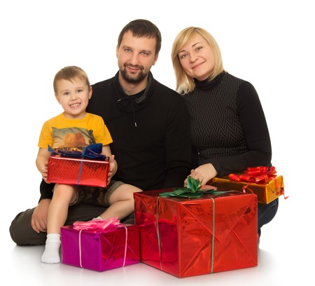 Happy family dad mom and their little son sitting on the floor surrounded by gifts - Isolated on white backgroundの写真素材