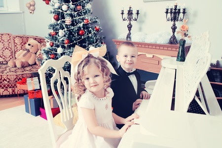 Little boy and girl playing the grand piano.の写真素材