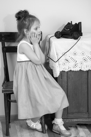 The girls ringing on the old phone.の写真素材