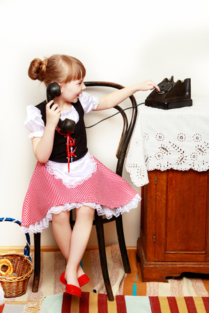 The girl is talking on the old phone.の写真素材