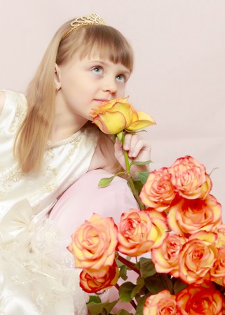 Girl sits next to a bouquet of flowers.の写真素材