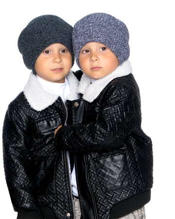 Two little boys in black jackets and hats.の写真素材