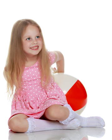Little girl is playing with a ballの写真素材