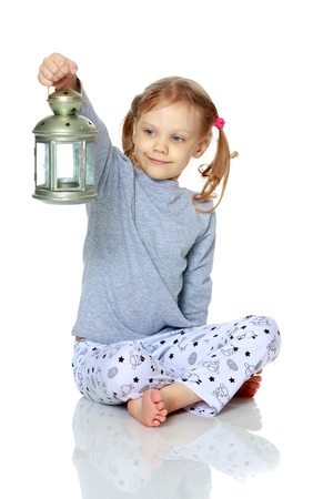 A little girl is holding a lamp.の写真素材