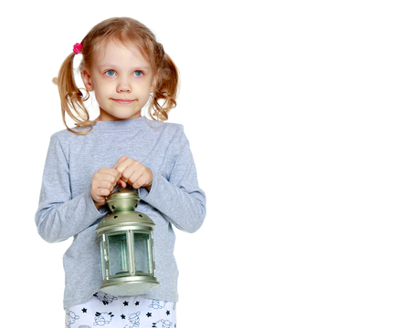 A little girl is holding a lamp.の写真素材