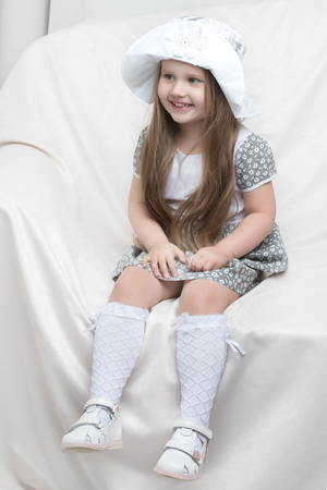 Little girl is sitting on the couchの写真素材