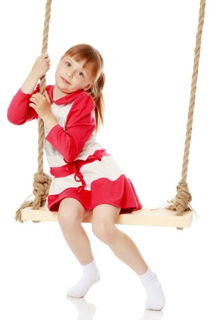 Little girl swinging on a swingの写真素材