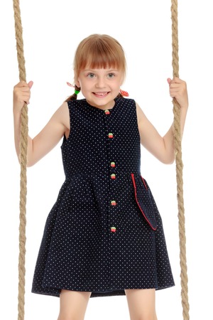 Little girl swinging on a swingの写真素材