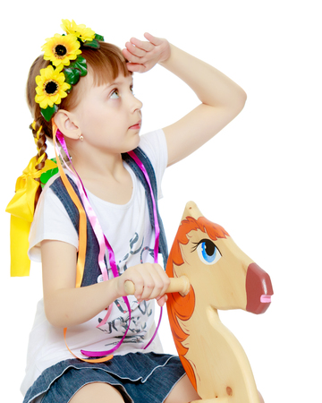 Little girl swinging on a wooden horse.の写真素材