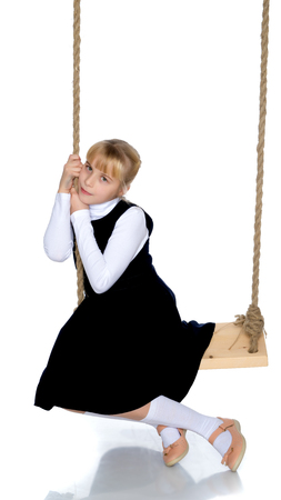 Little girl swinging on a swingの写真素材