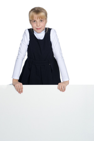 A little girl is looking from behind an empty banner.の写真素材