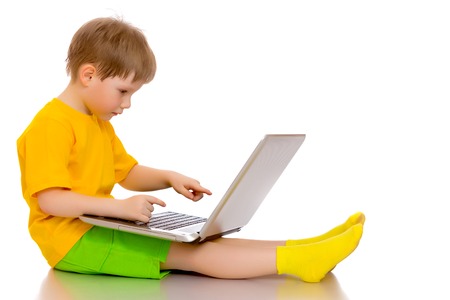 A little boy is working on a laptop.の写真素材