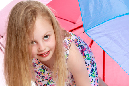 Little girl under an umbrella.の写真素材