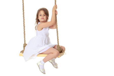 Little girl swinging on a swingの写真素材