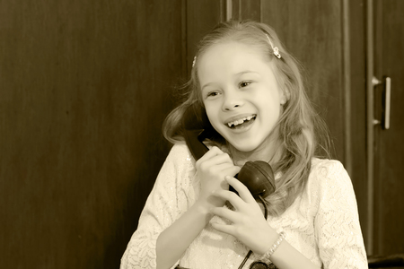 Girl talking on old phone.の写真素材