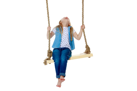 Little girl swinging on a swingの写真素材