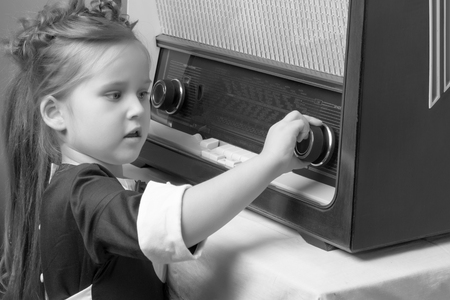 The girl is at the old radio.の写真素材