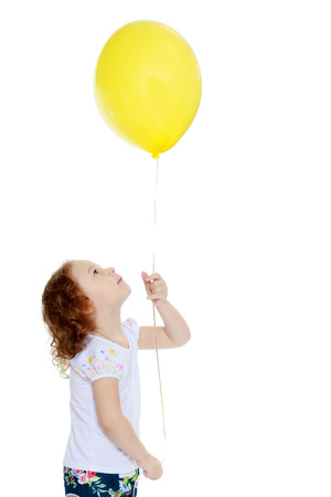 Little girl is playing with a balloonの写真素材
