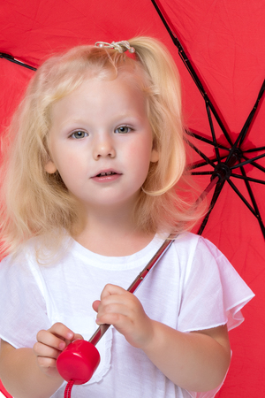 Little girl under an umbrella.の写真素材