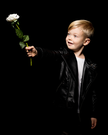 A little boy holds a flower in his hand.の写真素材