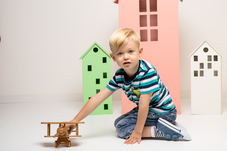 Little boy playing with wooden planeの写真素材