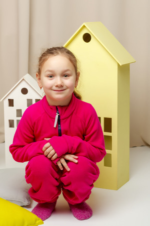 Little girl is playing with wooden houses.の写真素材