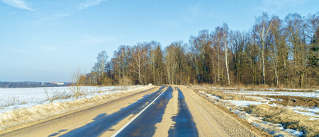 Asphalt road in early spring near the forest.