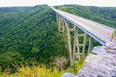 Beautiful arched bridge over a deep gorge, among dense tropical vegetation. Republic of Cubaの写真素材