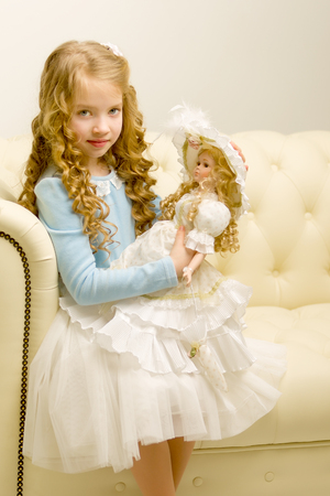 Cute little girl playing with a doll.の写真素材