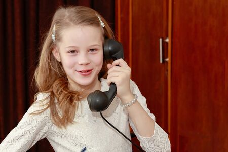 Girl talking on old phone.の写真素材