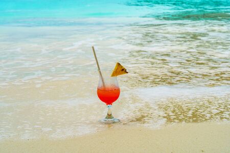 Glass of cocktail is on sandy coral beach, Maldives, The Indianの写真素材