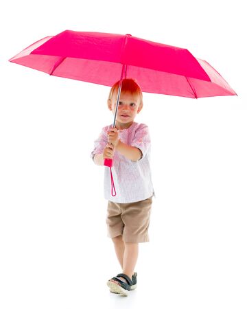 A cute little boy took cover under an umbrella.の写真素材