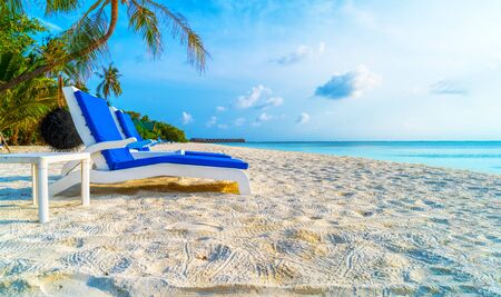 Lounge chairs on a beautiful tropical beach at Maldives