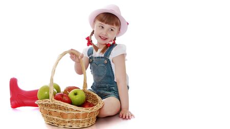 Little girl with a basket of apples.Isolated on white backgroundの写真素材