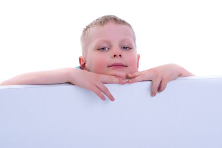 A little boy is looking from behind an empty banner.の写真素材