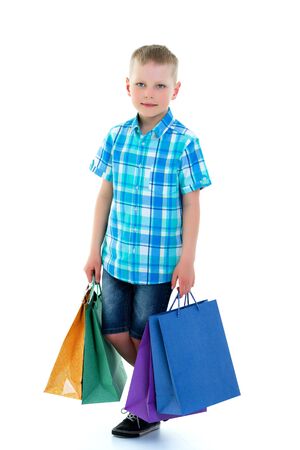 Little boy waving multicolored paper bags. He goes shoppingの写真素材