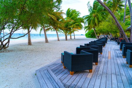 Wooden table and chairs by the tropical warm sea. Maldivesの写真素材