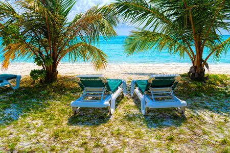 Lounge chairs on a beautiful tropical beach at Maldivesの写真素材