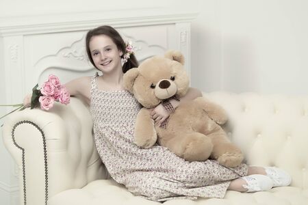 Beautiful teenager girl of school age sitting on the couch withの写真素材