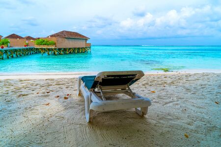 Along the azure sea there are sun loungers for visitors to relax. Maldives, the concept of family vacations, tourism.の写真素材