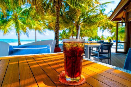 A glass of cold cocktail on a table on the beach in a restaurant